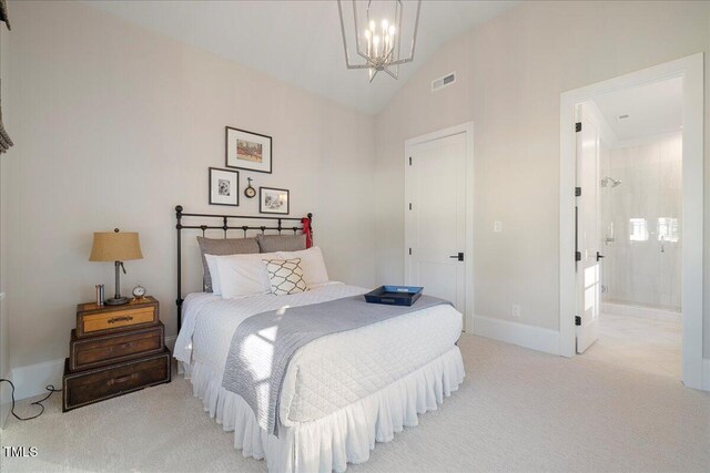 bedroom with an inviting chandelier, light colored carpet, connected bathroom, and vaulted ceiling