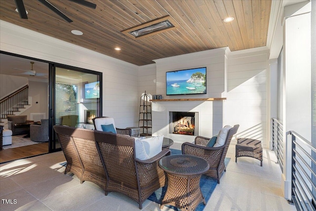 living room with crown molding, ceiling fan, wood ceiling, and exterior fireplace