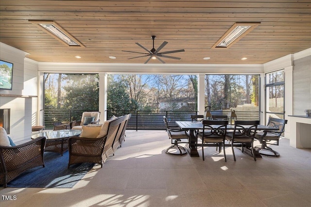 sunroom featuring plenty of natural light, wood ceiling, and a skylight