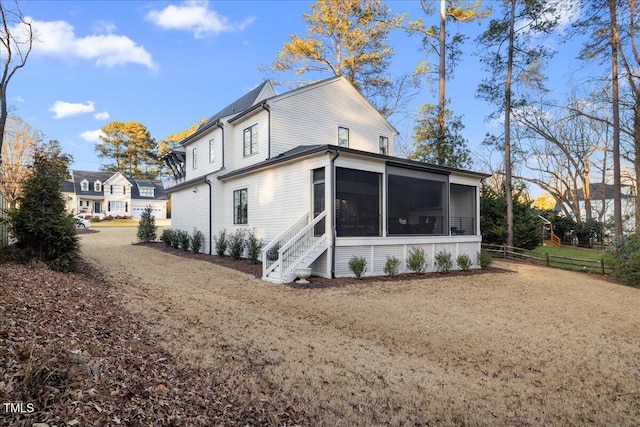 back of property featuring a yard and a sunroom