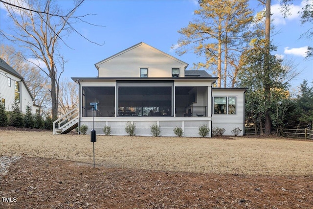 back of property with a sunroom and a yard