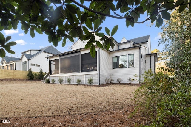 rear view of house featuring a sunroom