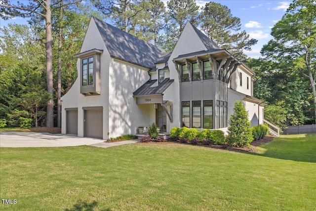 1304 Ivy Ln, Raleigh, NC 27609 - view of front facade featuring a garage, a front yard, a standing seam roof, a shingled roof, and driveway