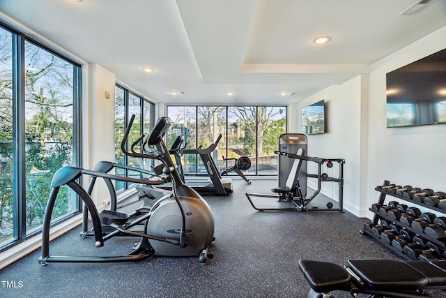 exercise room featuring recessed lighting, expansive windows, baseboards, and visible vents