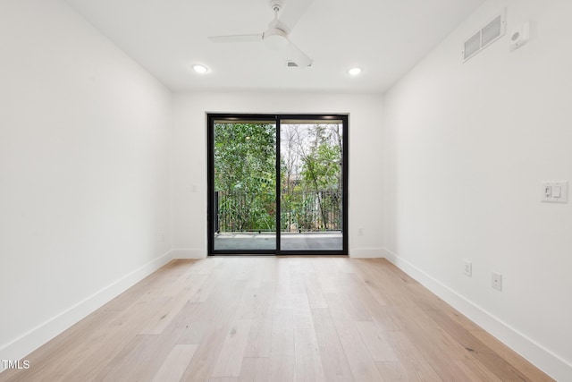 spare room featuring visible vents, ceiling fan, light wood-type flooring, and baseboards