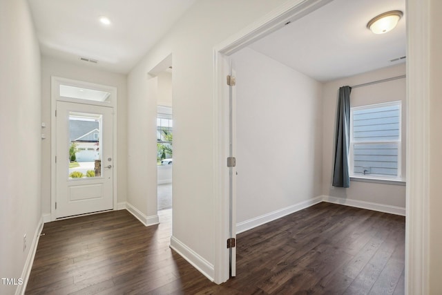 foyer entrance featuring dark wood-style floors, visible vents, and baseboards