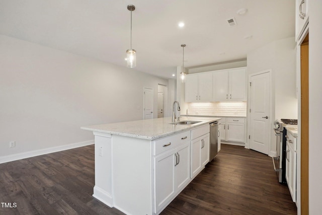 kitchen featuring dark wood-type flooring, a sink, stainless steel appliances, white cabinetry, and backsplash