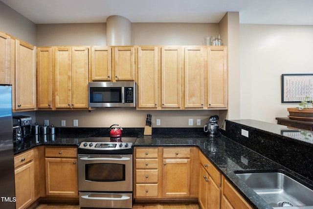 317 W Morgan St Unit 405, Raleigh, NC 27601 - kitchen featuring appliances with stainless steel finishes, dark stone countertops, light wood-style flooring, and light brown cabinets