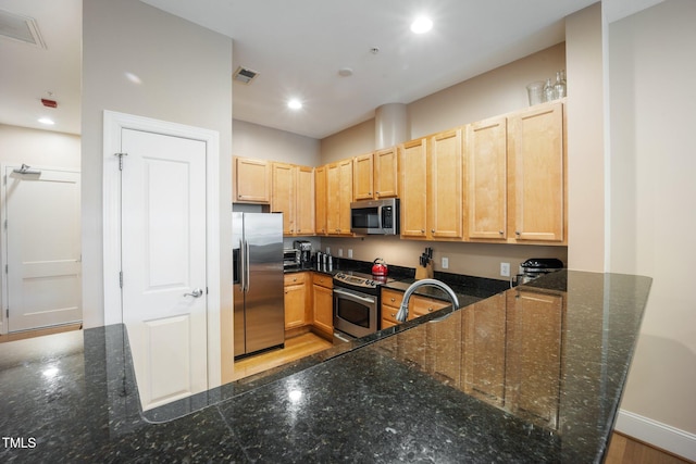 317 W Morgan St Unit 405, Raleigh, NC 27601 - kitchen with appliances with stainless steel finishes, light brown cabinetry, recessed lighting, dark stone counters, and a peninsula