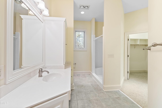 bathroom featuring a shower and vanity