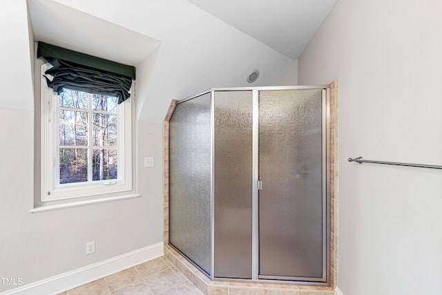 bathroom with vaulted ceiling, tile patterned floors, and a shower with shower door