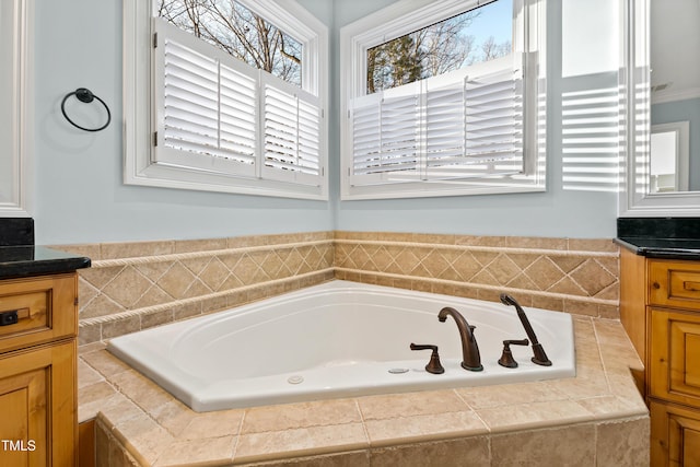 bathroom with vanity and a relaxing tiled tub