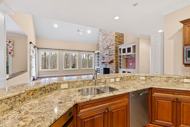 kitchen featuring a fireplace, sink, stainless steel appliances, crown molding, and light stone countertops