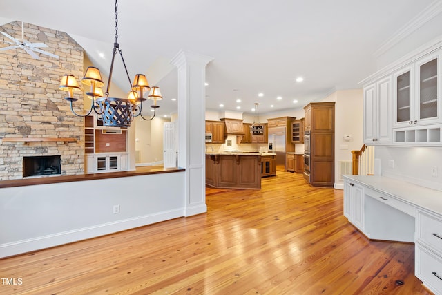 kitchen featuring a breakfast bar area, a center island, ornamental molding, pendant lighting, and stainless steel appliances