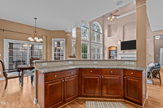 kitchen featuring stone counters, light wood-style flooring, and pendant lighting