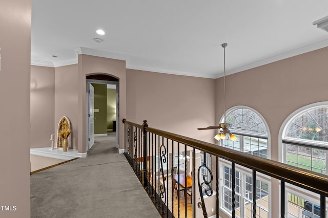 hall with ornamental molding, carpet, and baseboards