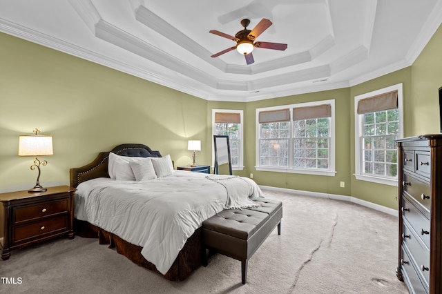 carpeted bedroom with baseboards, multiple windows, ornamental molding, and a raised ceiling