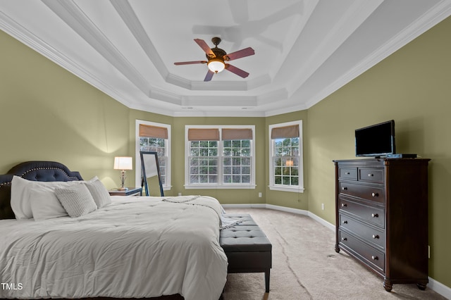 carpeted bedroom with a ceiling fan, baseboards, a raised ceiling, and crown molding