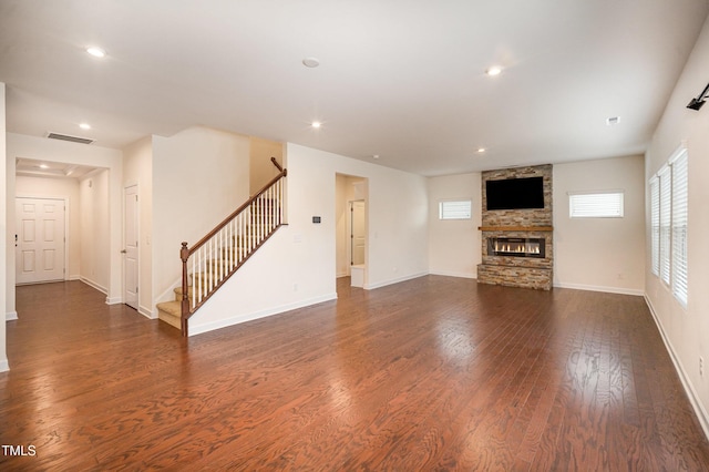 unfurnished living room with dark wood-type flooring and a fireplace