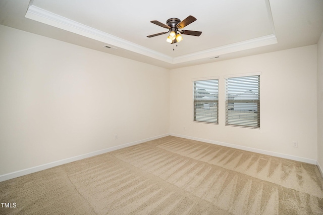 spare room featuring ceiling fan, carpet flooring, and a raised ceiling