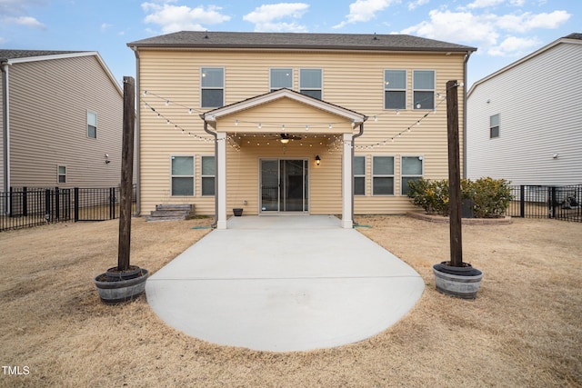 back of property with a lawn and a patio