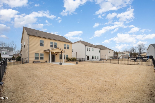 rear view of house featuring a lawn and a patio