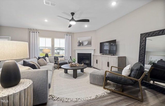 living room featuring dark wood-type flooring and ceiling fan