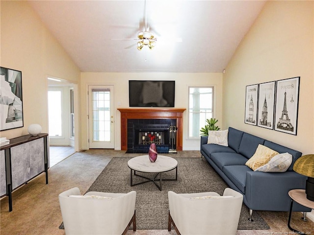 living room with a tile fireplace, high vaulted ceiling, light carpet, and ceiling fan