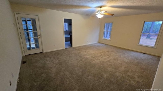 unfurnished room with ceiling fan, a wealth of natural light, a textured ceiling, and carpet flooring