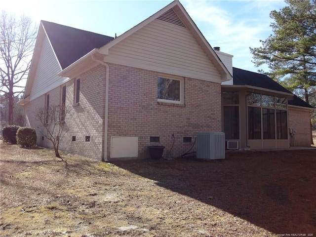 view of side of home featuring cooling unit and a sunroom