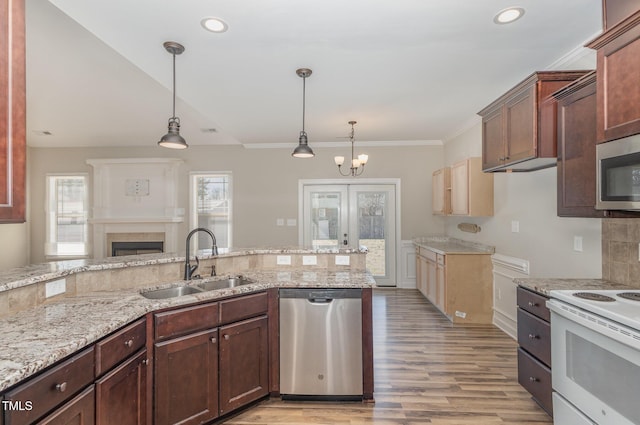 kitchen featuring sink, light hardwood / wood-style flooring, stainless steel appliances, ornamental molding, and decorative light fixtures