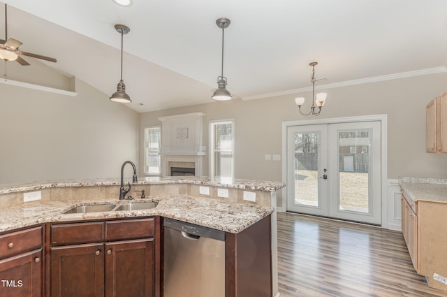 kitchen featuring stainless steel dishwasher, decorative light fixtures, sink, and light hardwood / wood-style flooring