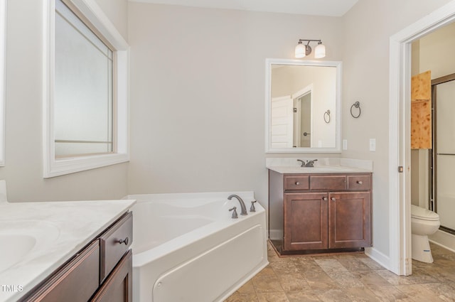 bathroom featuring vanity, a bathtub, and toilet