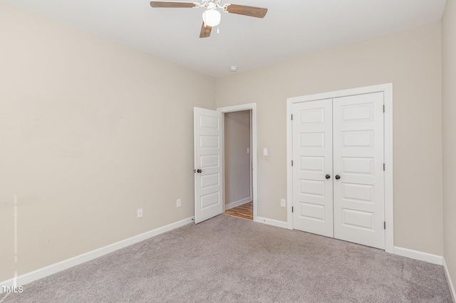 unfurnished bedroom with ceiling fan, light colored carpet, and a closet