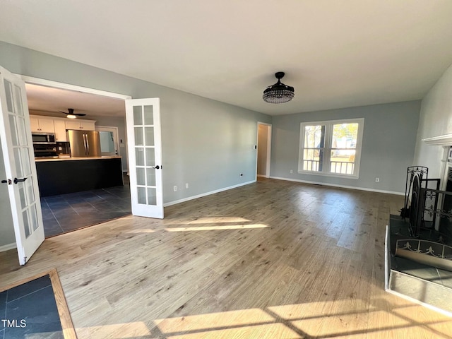 unfurnished living room with hardwood / wood-style floors and french doors