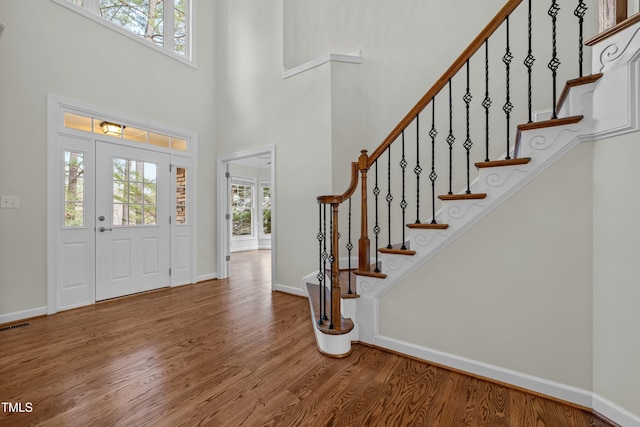 foyer with baseboards, plenty of natural light, and wood finished floors