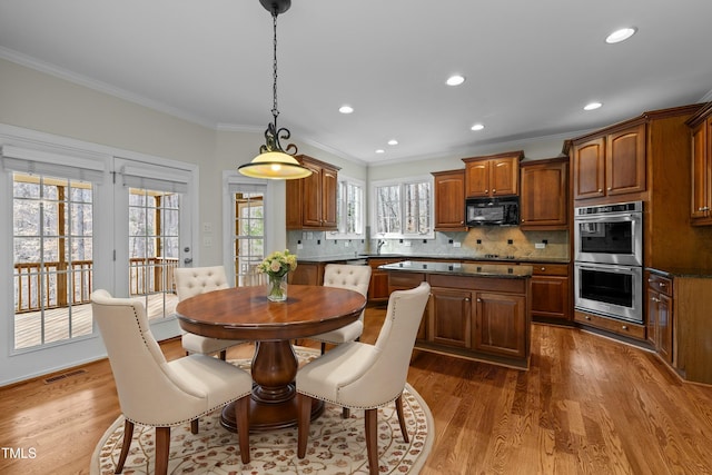 dining room featuring recessed lighting, wood finished floors, visible vents, and ornamental molding