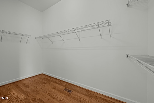 spacious closet featuring visible vents and wood finished floors