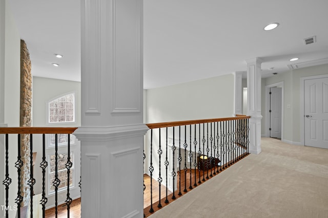 hallway with baseboards, decorative columns, recessed lighting, light carpet, and an upstairs landing