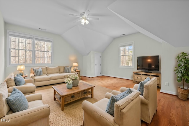 living room featuring visible vents, baseboards, light wood-style floors, and vaulted ceiling