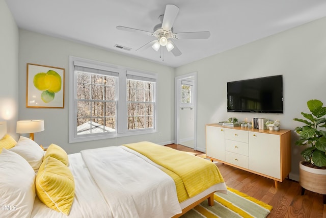 bedroom featuring ceiling fan, visible vents, and wood finished floors