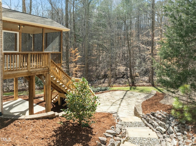 view of yard with stairs, a patio, and a sunroom