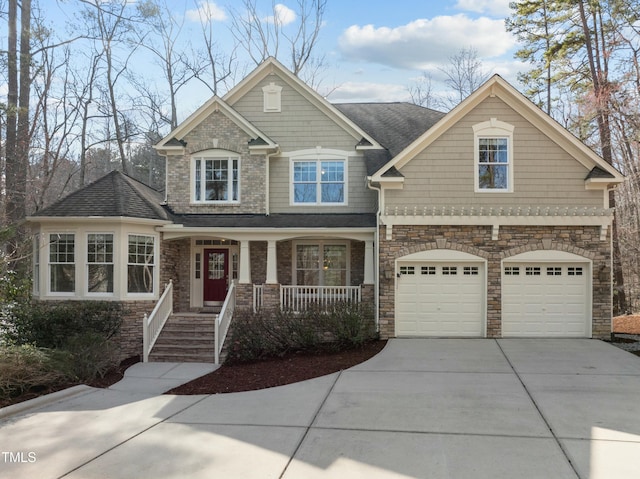 craftsman-style house with a porch, a garage, driveway, and roof with shingles