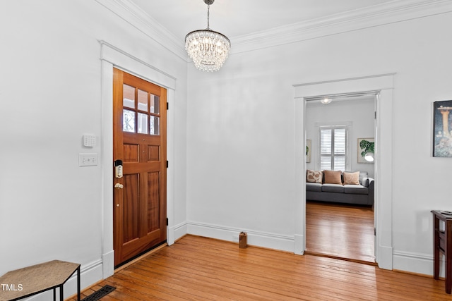 entryway featuring visible vents, baseboards, an inviting chandelier, crown molding, and light wood-style floors