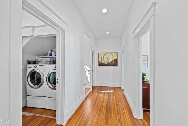 washroom featuring laundry area, independent washer and dryer, light wood-style flooring, and baseboards