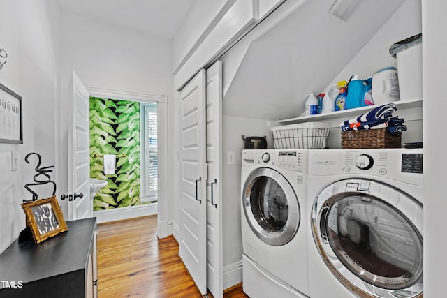 laundry room with laundry area, washer and clothes dryer, baseboards, and wood finished floors