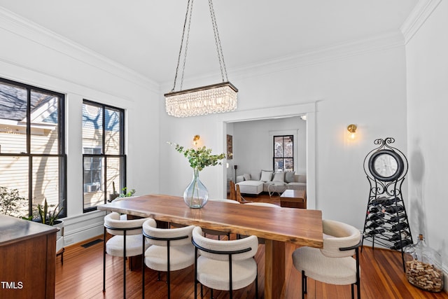 dining area featuring ornamental molding, hardwood / wood-style flooring, plenty of natural light, and visible vents