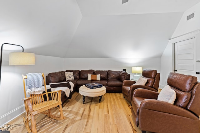 living room with lofted ceiling, baseboards, visible vents, and light wood finished floors