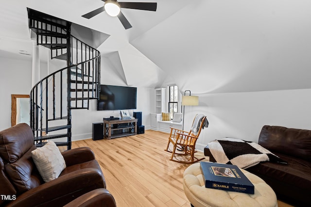 living room featuring stairs, baseboards, vaulted ceiling, and wood finished floors