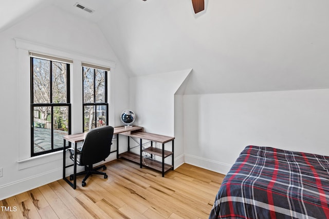 bedroom with lofted ceiling, visible vents, baseboards, and wood finished floors